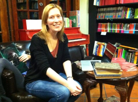 Heather O'Donnell at the Community Bookstore meeting, living-room style. Plenty of social skill goes into face-to-face book evaluations, and the rare book expert never knows what to expect. (Partially visible behind Heather is her young daughter, sitting sideways, absorbed by "The Guiness Book Of Records, 2013."